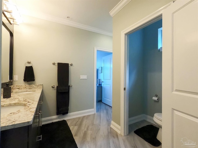 bathroom featuring toilet, crown molding, hardwood / wood-style flooring, and vanity