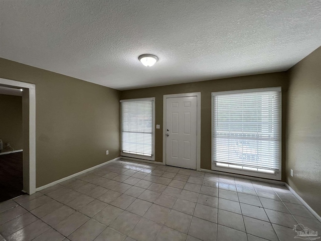 tiled foyer with a textured ceiling