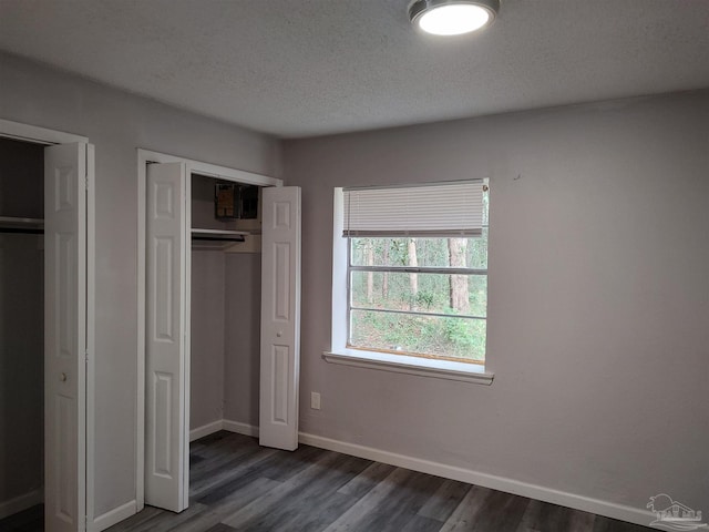 unfurnished bedroom featuring dark hardwood / wood-style floors and a textured ceiling