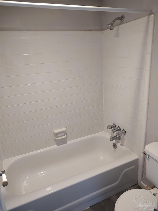 bathroom featuring toilet and tiled shower / bath combo