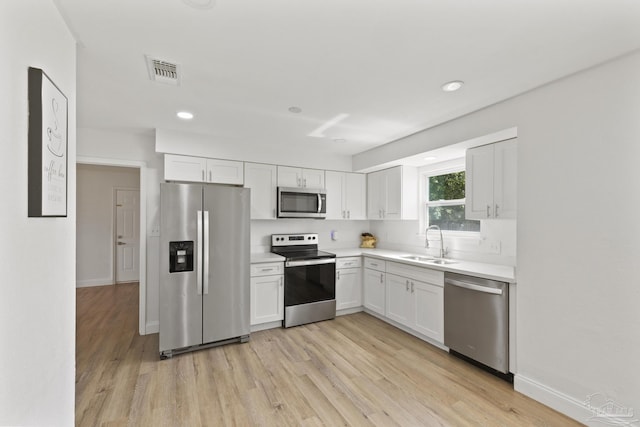 4224 Seaport Rd, Pace, FL 32571 - kitchen featuring appliances with stainless steel finishes, a sink, light wood finished floors, white cabinets, and recessed lighting