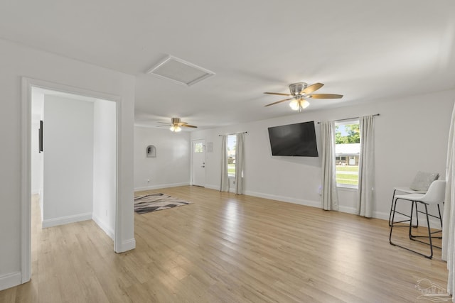 4224 Seaport Rd, Pace, FL 32571 - unfurnished living room with light wood-style flooring, ceiling fan, attic access, and baseboards