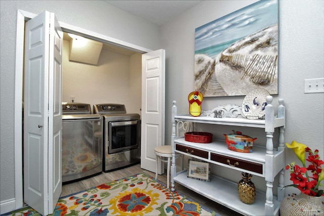 laundry area featuring washing machine and dryer and hardwood / wood-style floors