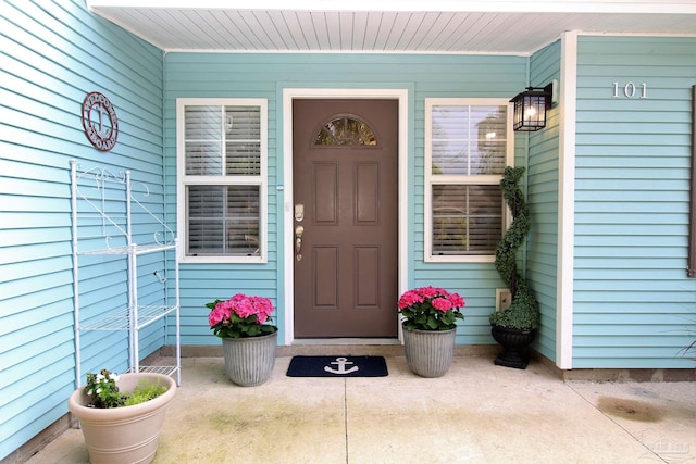 view of exterior entry featuring covered porch