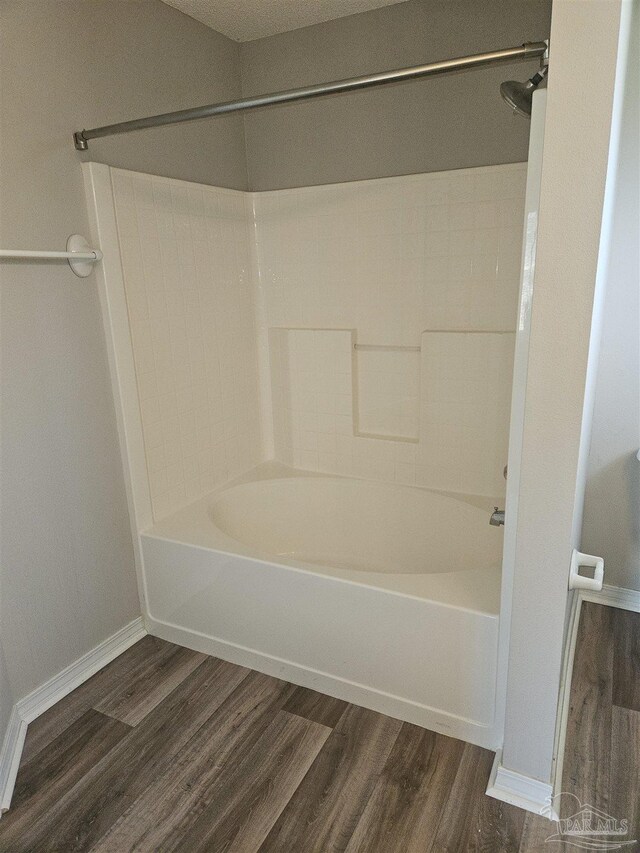 bathroom with hardwood / wood-style floors and bathtub / shower combination