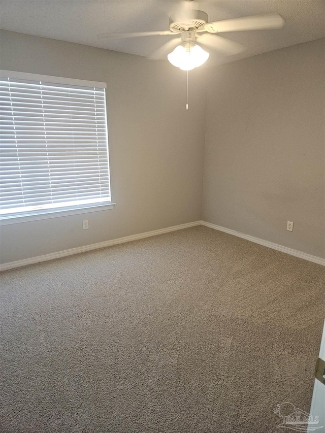 spare room with carpet flooring, ceiling fan, and baseboards