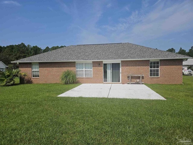 rear view of house featuring a patio and a yard