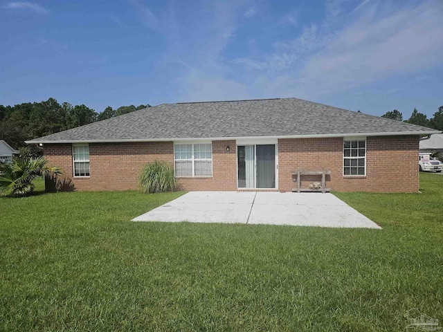 back of property featuring a yard, roof with shingles, and a patio