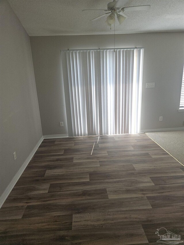 empty room with ceiling fan, wood-type flooring, and plenty of natural light