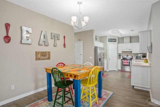 dining area featuring dark hardwood / wood-style floors and an inviting chandelier