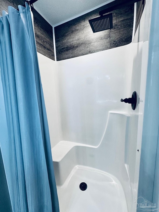 bathroom featuring curtained shower and a textured ceiling