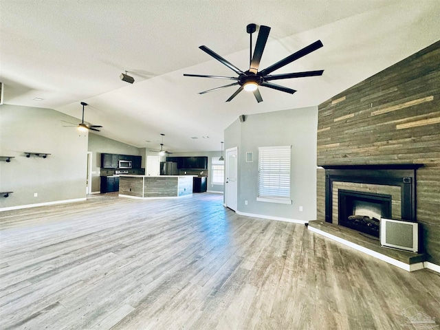 unfurnished living room with lofted ceiling, a textured ceiling, and wood-type flooring