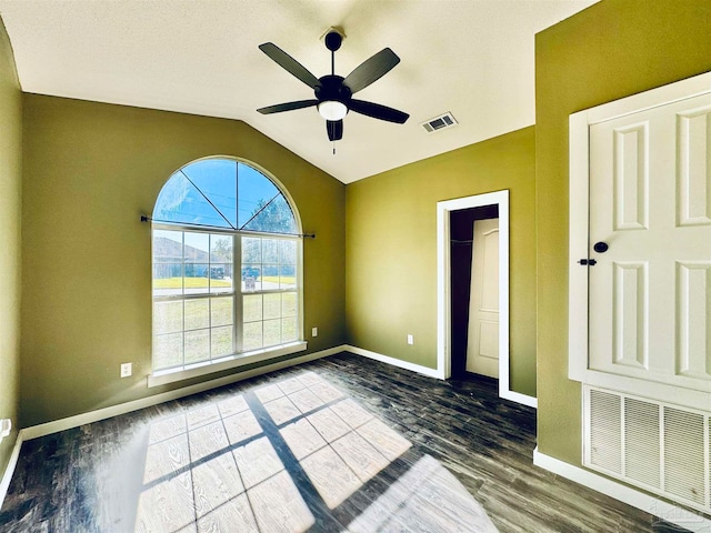 spare room with wood-type flooring, ceiling fan, and vaulted ceiling