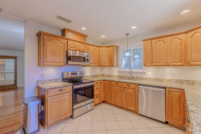 kitchen with appliances with stainless steel finishes, a textured ceiling, sink, light tile patterned floors, and decorative light fixtures