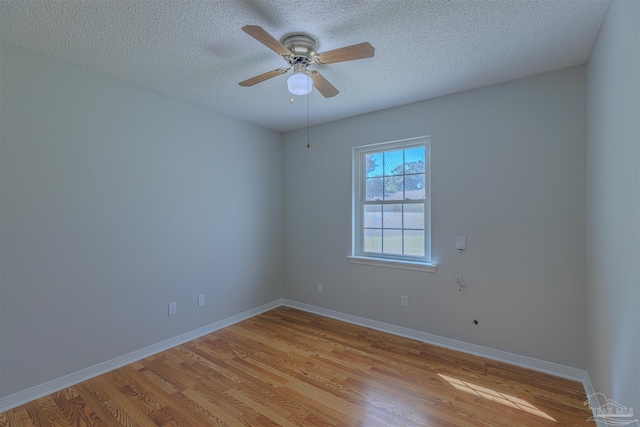 spare room featuring ceiling fan, light wood-type flooring, and a textured ceiling