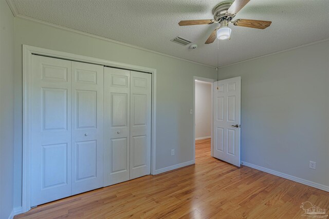 4679 E Spencer Field Rd, Pace, FL 32571 - unfurnished bedroom with ornamental molding, a textured ceiling, a closet, and light wood finished floors