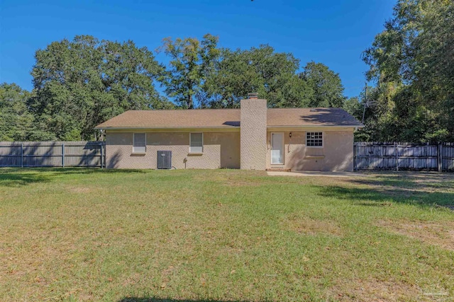 back of property featuring central air condition unit and a lawn