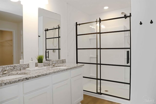 bathroom with vanity, hardwood / wood-style floors, and walk in shower