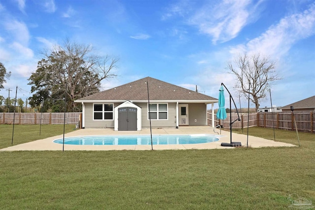 rear view of house featuring a fenced in pool and a lawn