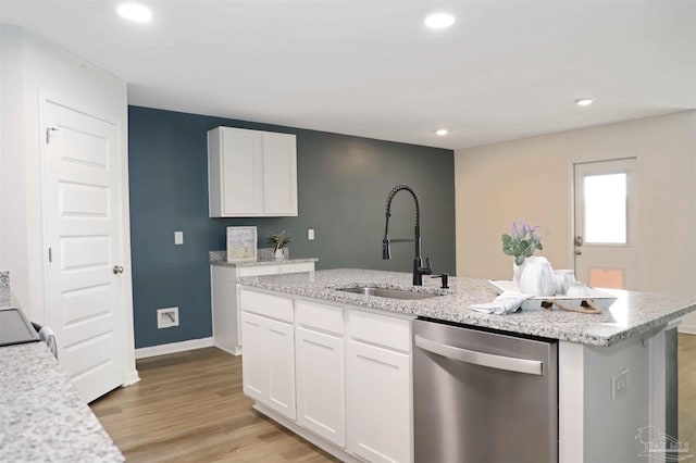 kitchen featuring sink, white cabinets, stainless steel dishwasher, a center island with sink, and light wood-type flooring