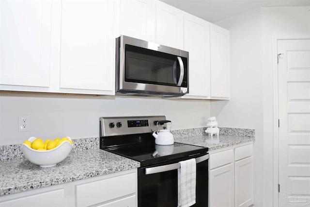 kitchen featuring light stone counters, white cabinets, and appliances with stainless steel finishes