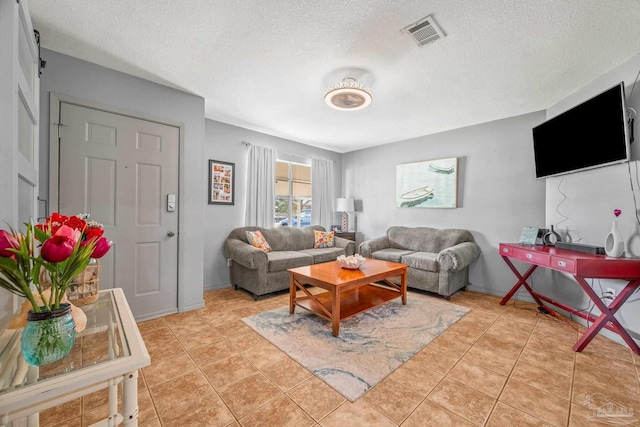 living room featuring baseboards, visible vents, a textured ceiling, and light tile patterned flooring