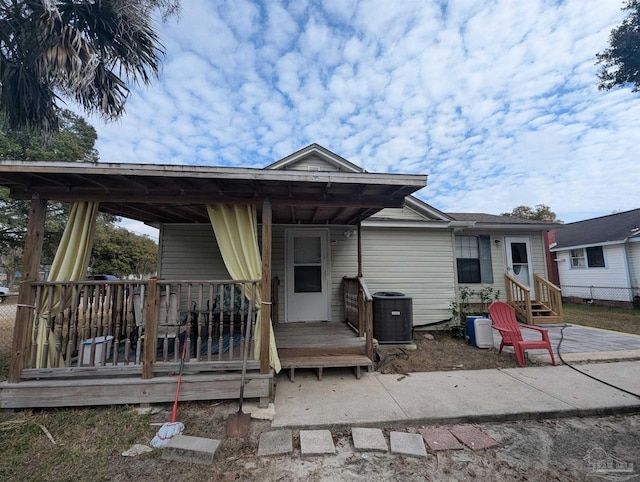 back of property with central air condition unit and entry steps