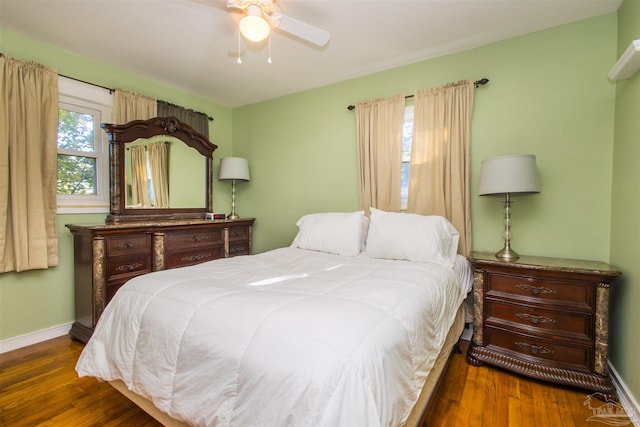 bedroom with dark hardwood / wood-style flooring and ceiling fan