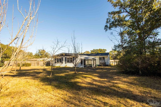 rear view of house featuring a yard