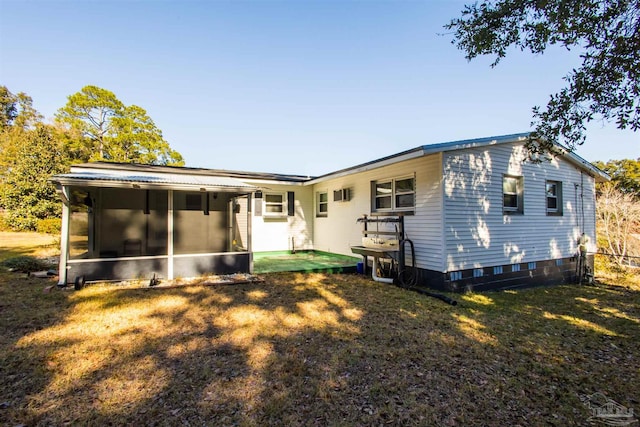 rear view of house with a sunroom and a yard