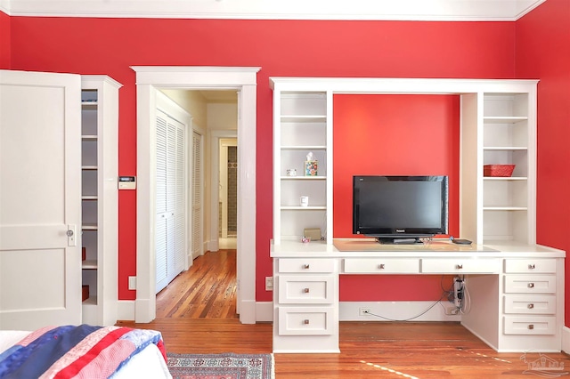 bedroom with light wood-type flooring and built in desk