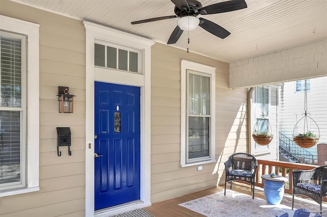 view of exterior entry featuring ceiling fan and a porch