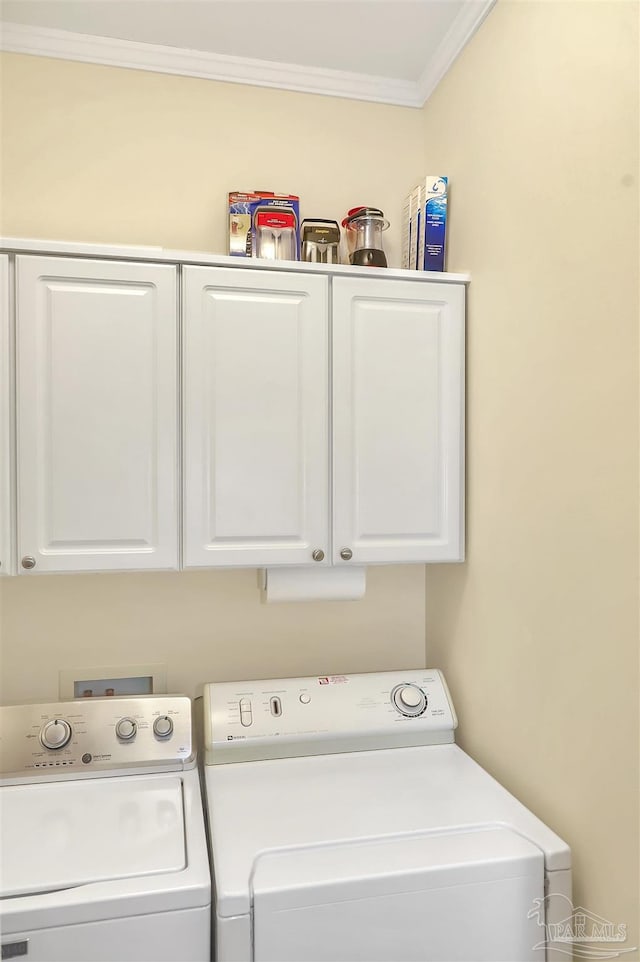 laundry area featuring cabinet space, washer and clothes dryer, and crown molding