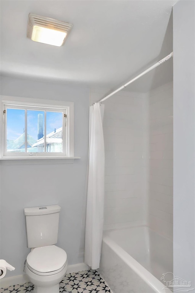 bathroom featuring baseboards, shower / bathtub combination with curtain, toilet, and tile patterned floors