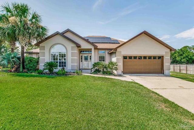 view of front of home featuring a garage, a front yard, and solar panels