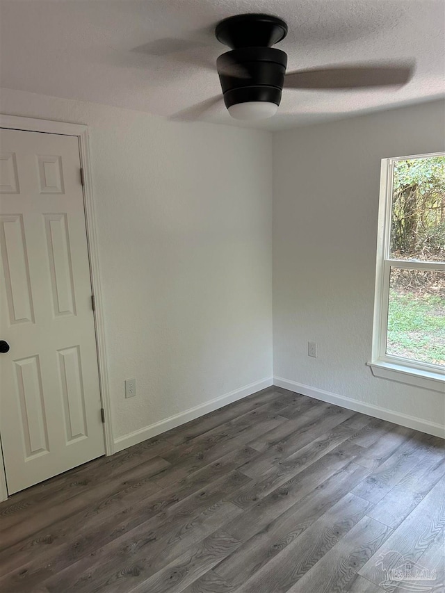 unfurnished room with a textured ceiling and dark hardwood / wood-style flooring