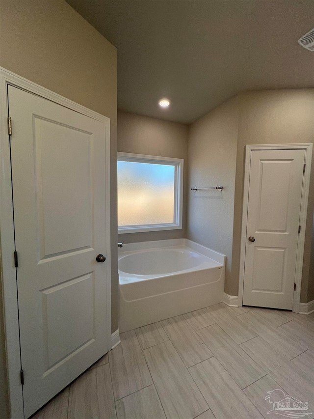 bathroom with tile patterned floors and a bathtub