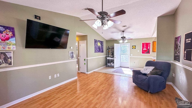 sitting room featuring hardwood / wood-style flooring, vaulted ceiling, and a textured ceiling