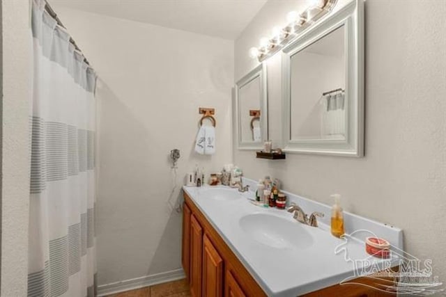 bathroom featuring tile patterned floors, vanity, and curtained shower