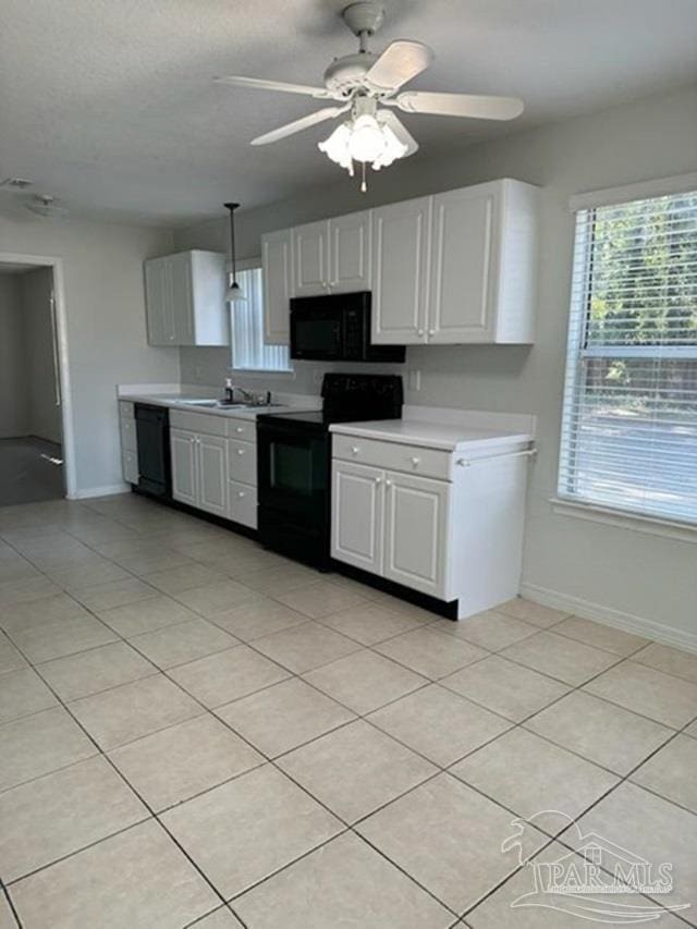 kitchen featuring pendant lighting, black appliances, ceiling fan, light tile patterned flooring, and white cabinetry