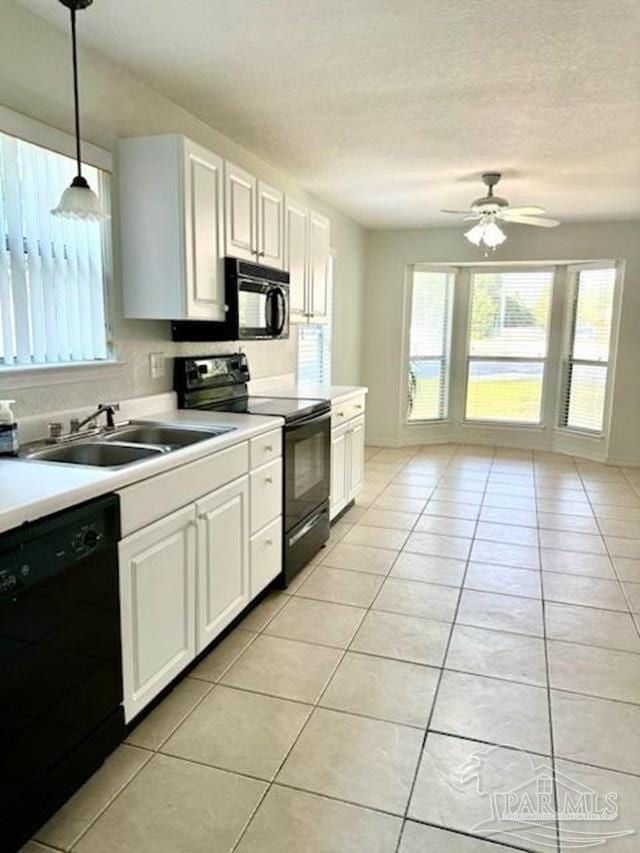 kitchen with ceiling fan, sink, black appliances, pendant lighting, and white cabinets