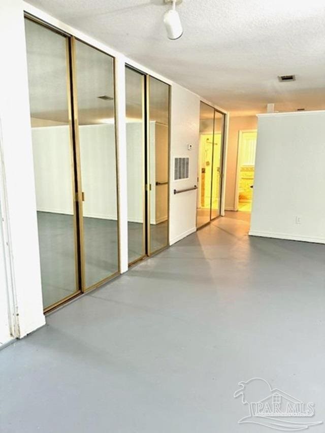 spare room with a textured ceiling and concrete floors