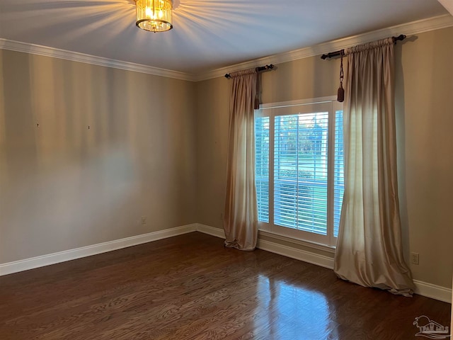 spare room featuring dark wood-style floors, baseboards, and ornamental molding