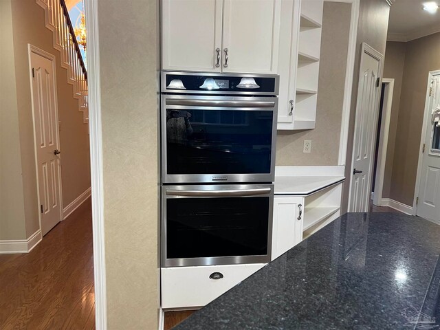 kitchen with open shelves, white cabinets, dark wood-type flooring, and stainless steel double oven