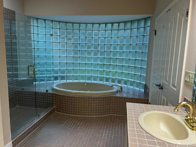 full bath with a sink, a garden tub, a stall shower, and tile patterned floors