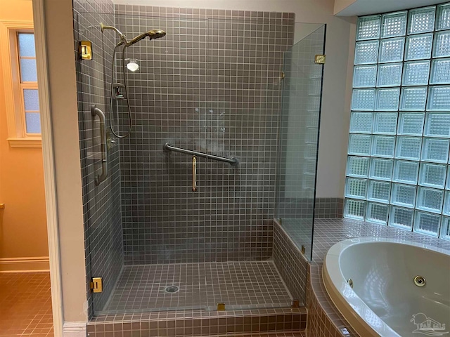 full bathroom featuring a jetted tub and a stall shower