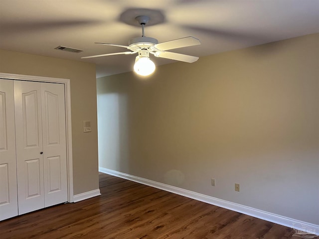 unfurnished bedroom with visible vents, baseboards, a closet, and dark wood finished floors