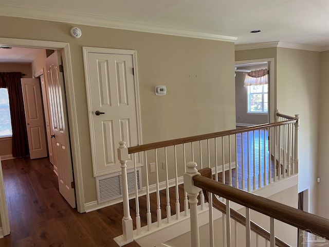 corridor with visible vents, crown molding, baseboards, an upstairs landing, and dark wood-style floors