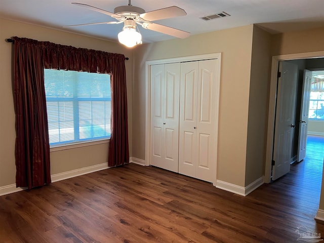 unfurnished bedroom featuring visible vents, a closet, and dark wood-style flooring