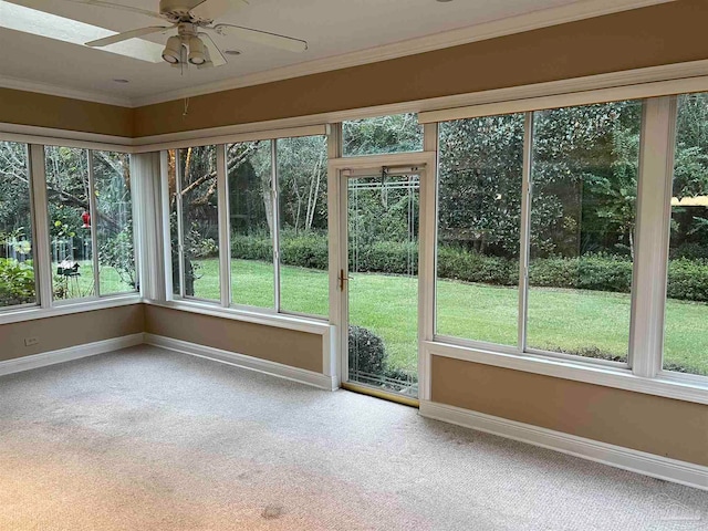 unfurnished sunroom featuring a wealth of natural light and ceiling fan